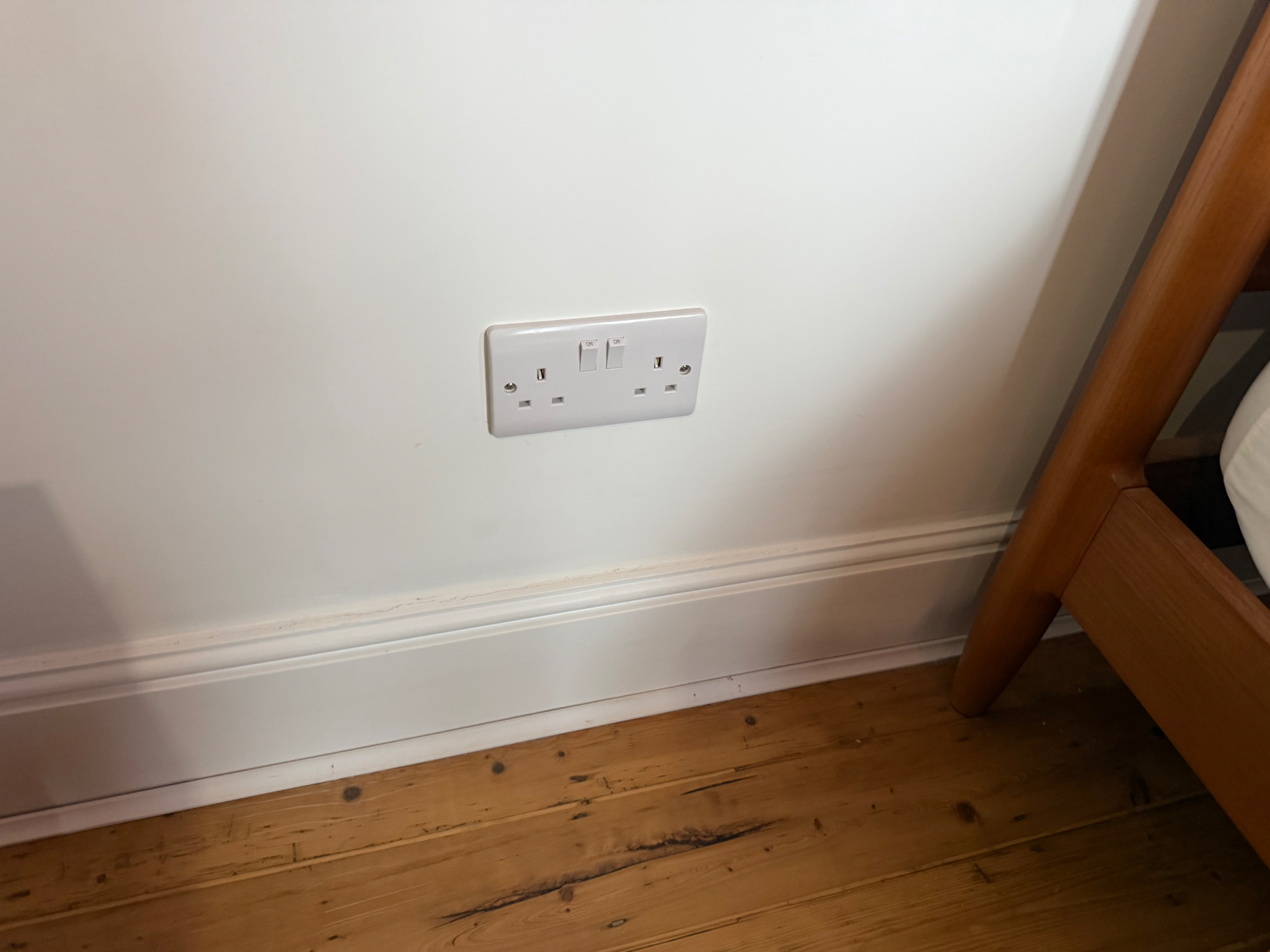 Finished twin 13A socket flush-fitted into a lath and plaster bedroom wall